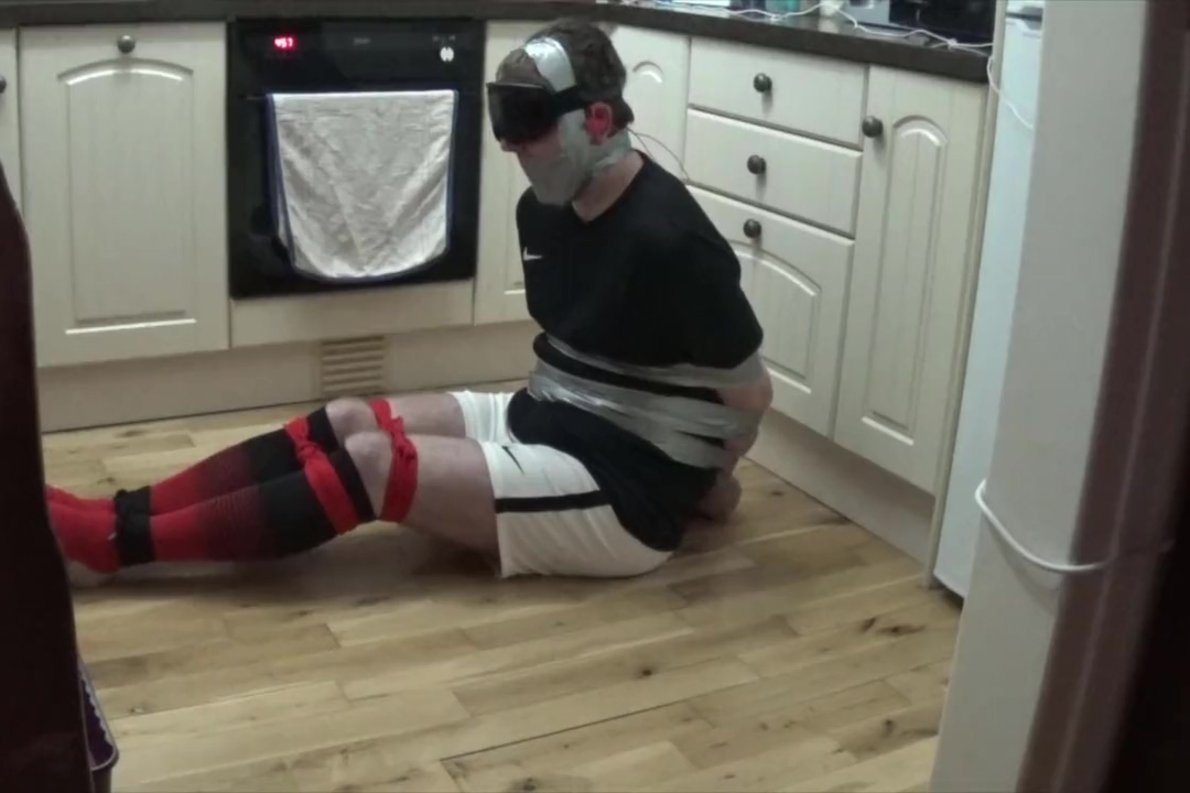 Footballer tied and taped tight on kitchen floor
